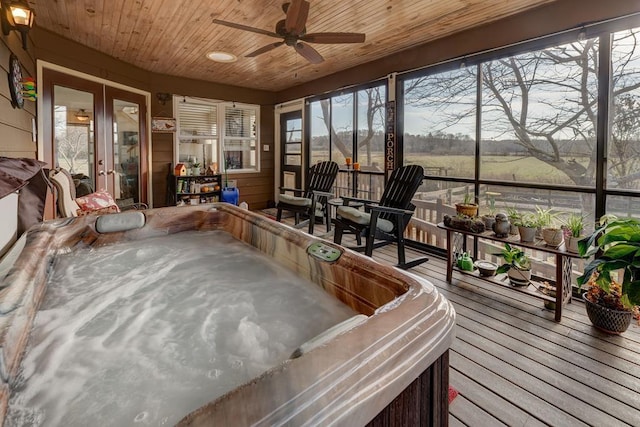 sunroom with ceiling fan, a rural view, a jacuzzi, wooden ceiling, and french doors