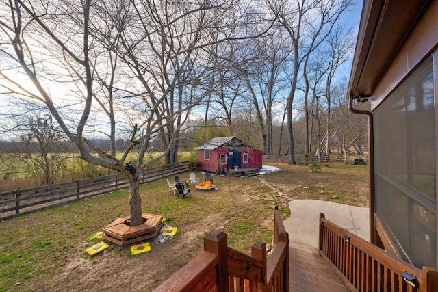 view of yard featuring an outdoor structure, a deck, and a fire pit