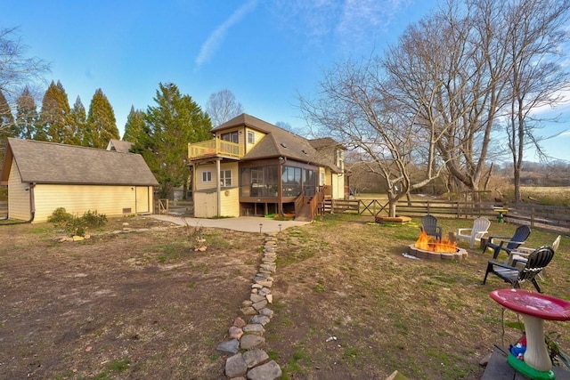 view of yard featuring a deck, a patio, an outdoor fire pit, a sunroom, and a balcony