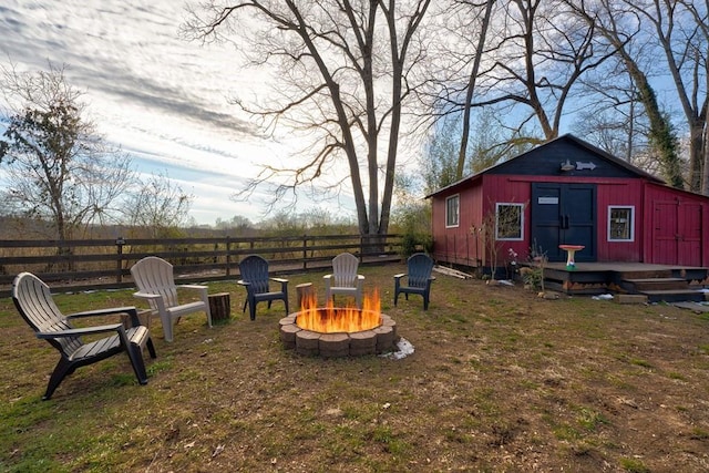 view of yard featuring an outdoor structure and a fire pit