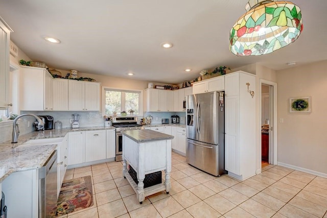 kitchen with stainless steel appliances, a center island, and white cabinets