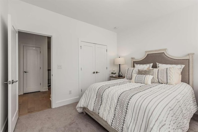 carpeted bedroom with baseboards and a closet