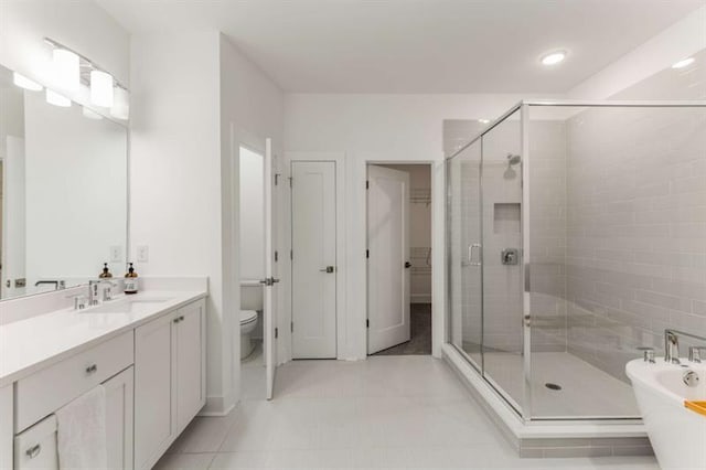 full bathroom with a freestanding bath, vanity, a stall shower, and a closet