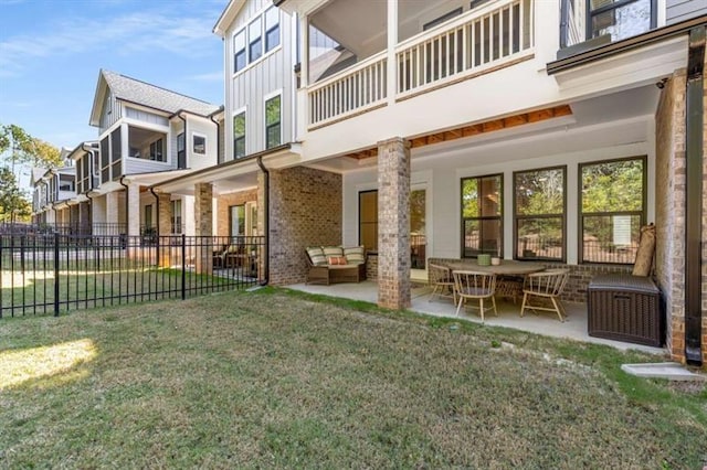 back of property featuring fence, board and batten siding, a lawn, and a patio area