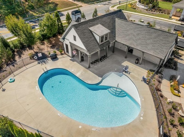 community pool featuring fence and a patio area