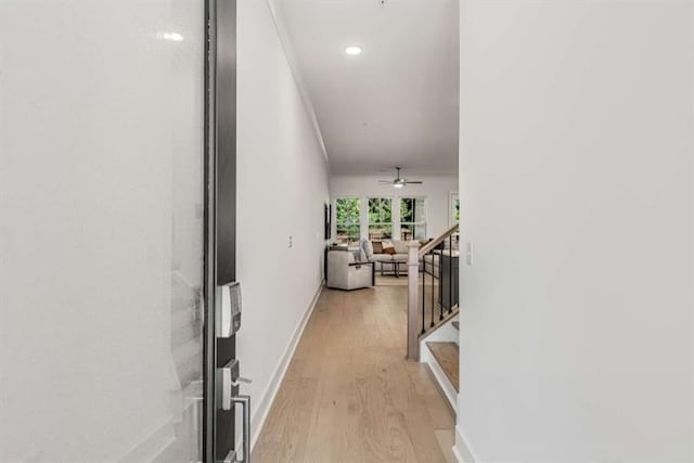hall featuring light wood-style floors, recessed lighting, baseboards, and stairway