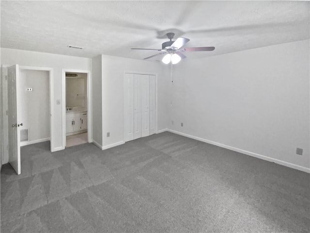 unfurnished bedroom with ceiling fan, ensuite bathroom, baseboards, and carpet