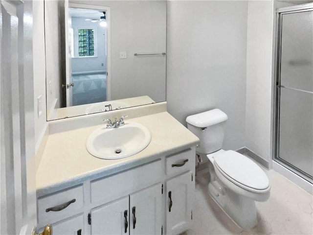 bathroom featuring toilet, a shower stall, ceiling fan, and vanity