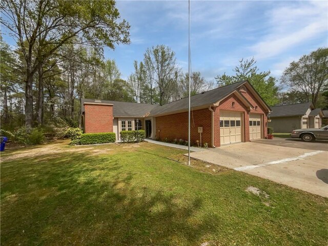 view of front of home with brick siding, driveway, a garage, and a front lawn