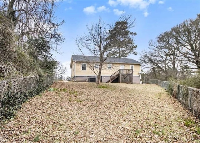 rear view of house featuring stairway and a fenced backyard