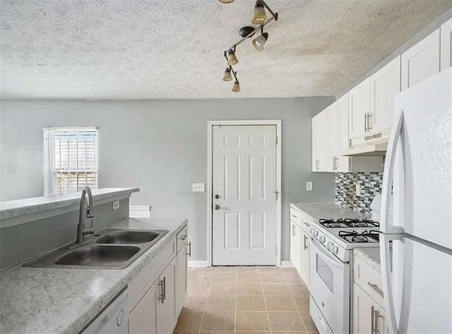 kitchen with under cabinet range hood, a sink, backsplash, white appliances, and white cabinets