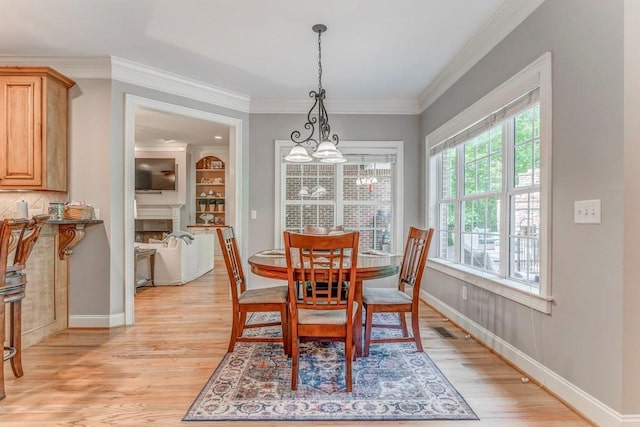 27 Bluff Mountain Dr SW, Rome, GA 30165 - dining room with a chandelier, light wood-style floors, crown molding, baseboards, and a fireplace