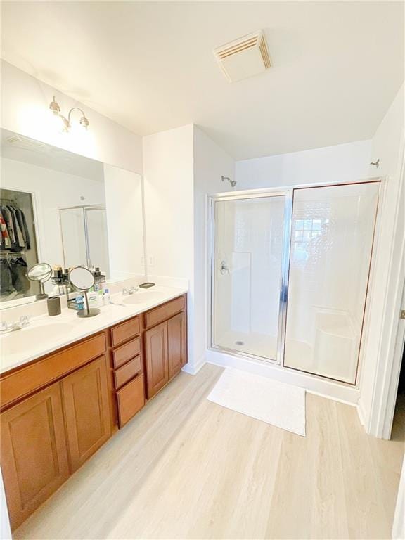 3130 Haynes Park Dr, Lithonia, GA 30038 - bathroom with wood finished floors, a shower stall, and double vanity