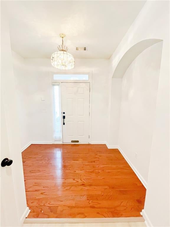 3130 Haynes Park Dr, Lithonia, GA 30038 - entrance foyer with a chandelier, wood finished floors, baseboards, and arched walkways