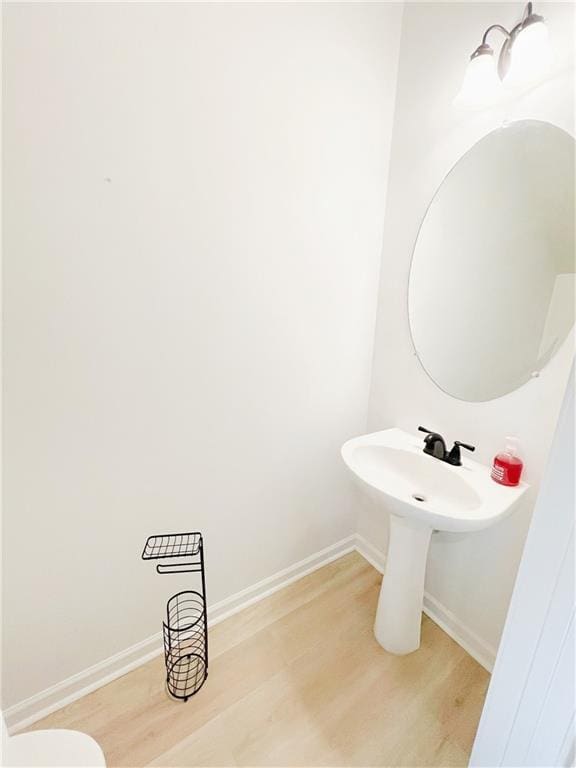 3130 Haynes Park Dr, Lithonia, GA 30038 - half bathroom featuring wood finished floors, baseboards, and toilet