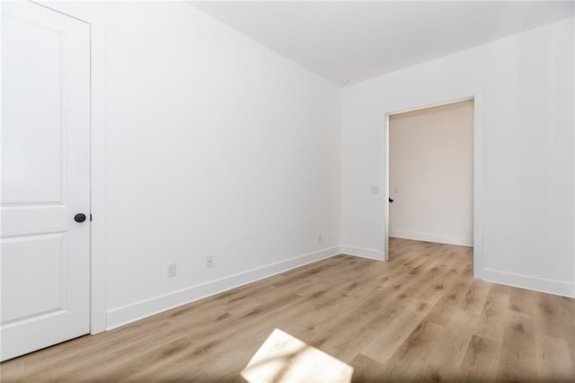 spare room featuring light wood-style floors and baseboards