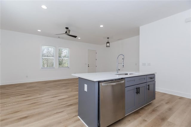 kitchen with a sink, baseboards, light countertops, stainless steel dishwasher, and light wood-type flooring