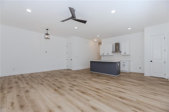 unfurnished living room with baseboards, ceiling fan, light wood-type flooring, and recessed lighting