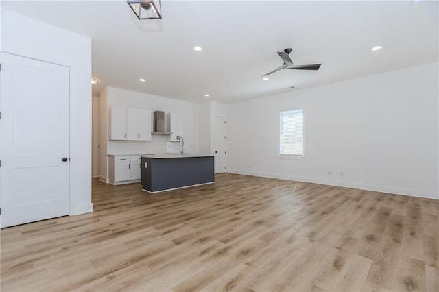 unfurnished living room with light wood finished floors, baseboards, a ceiling fan, and recessed lighting