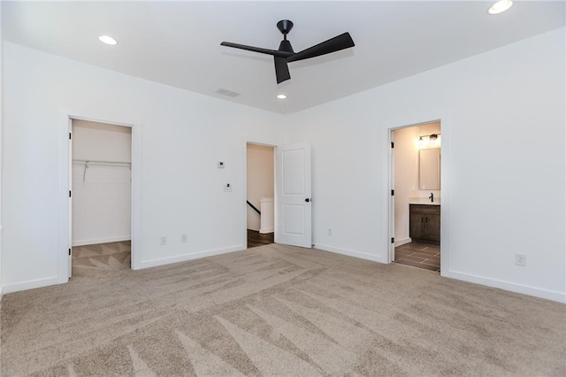 unfurnished bedroom featuring carpet floors, a walk in closet, visible vents, and recessed lighting