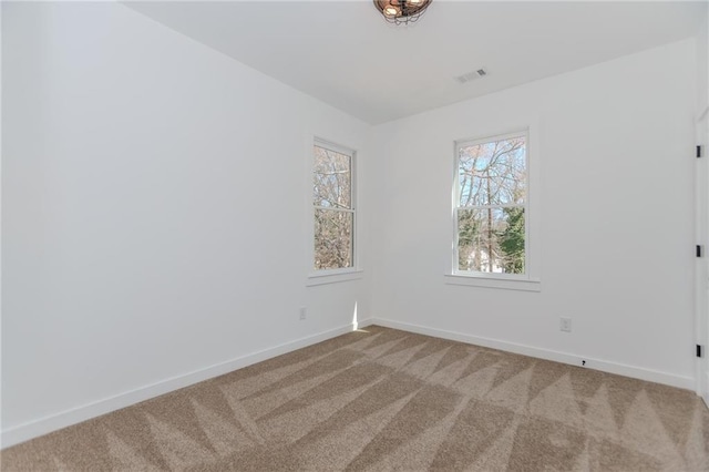 carpeted empty room with visible vents and baseboards