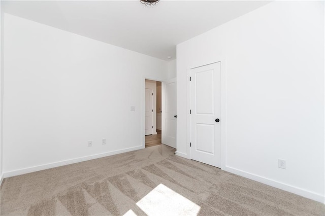 carpeted empty room featuring baseboards