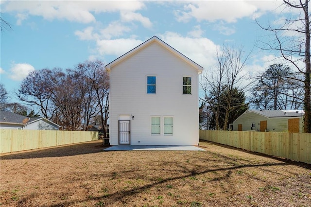 rear view of house with a yard, a fenced backyard, and a patio