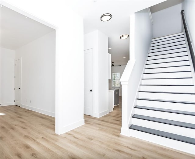 staircase with wood finished floors and baseboards