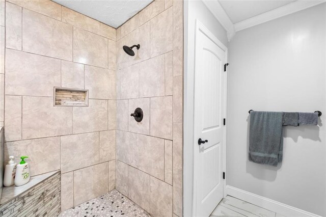 bathroom featuring a tile shower and ornamental molding