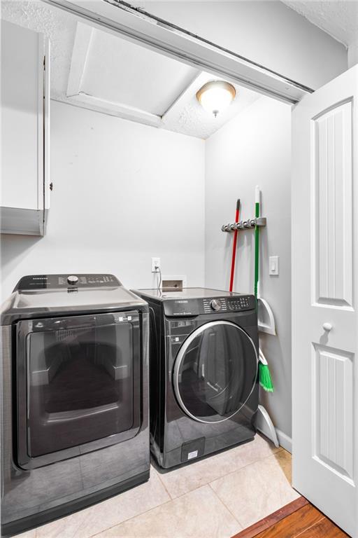 laundry room with light wood-type flooring and washer and clothes dryer