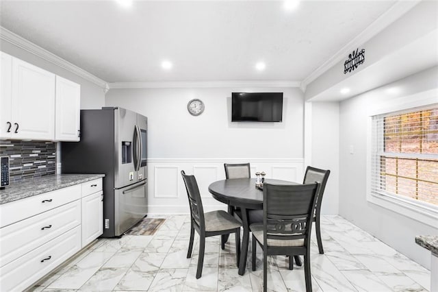 dining space featuring crown molding