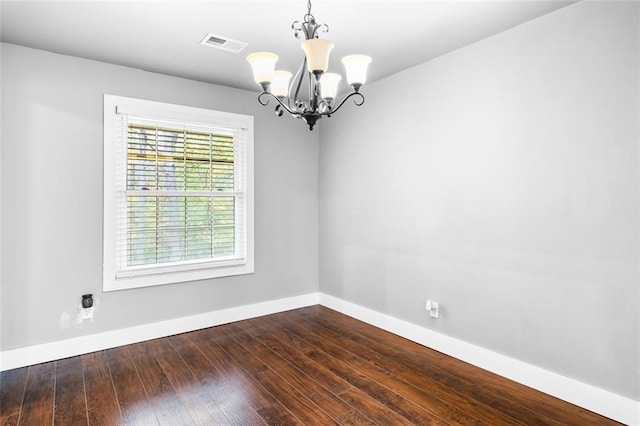 unfurnished room with dark hardwood / wood-style flooring and a notable chandelier