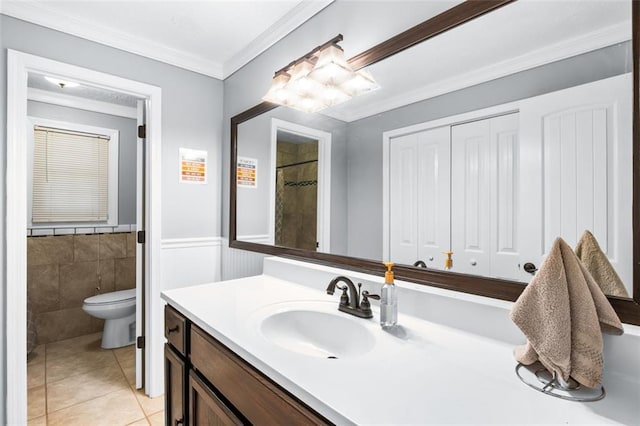 bathroom featuring tile patterned floors, toilet, vanity, tile walls, and ornamental molding