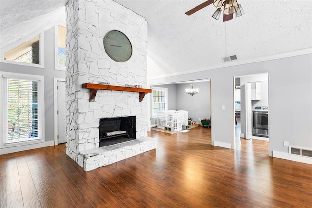 living room with hardwood / wood-style floors, a fireplace, a healthy amount of sunlight, and a textured ceiling