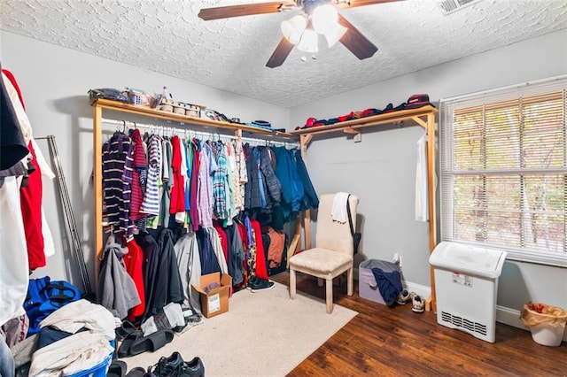 walk in closet featuring dark hardwood / wood-style floors and ceiling fan