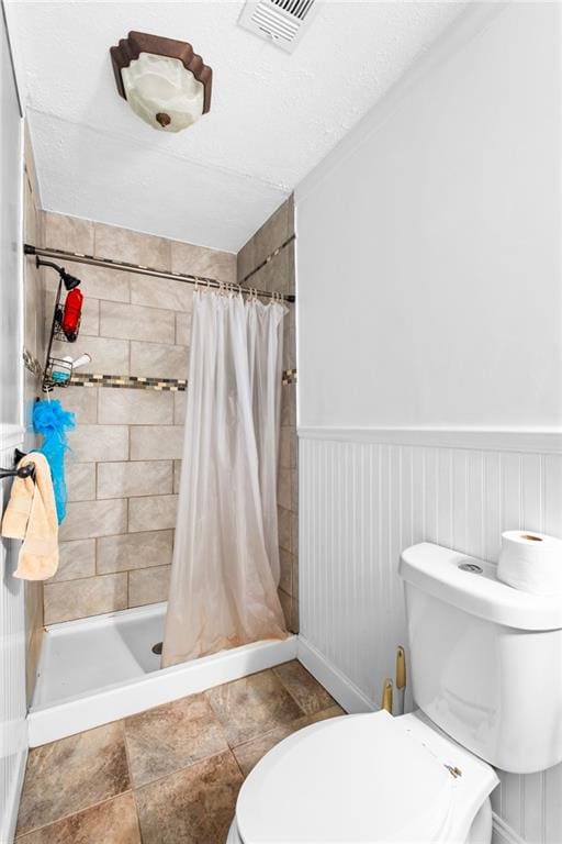 bathroom with a shower with curtain, a textured ceiling, and toilet