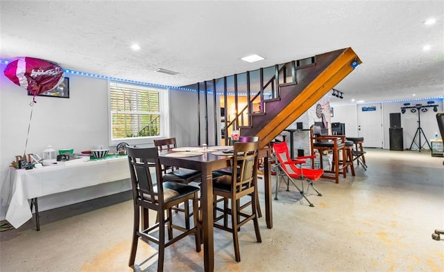 dining space featuring concrete flooring and a textured ceiling