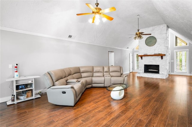 living room featuring lofted ceiling, ceiling fan, ornamental molding, a fireplace, and wood-type flooring