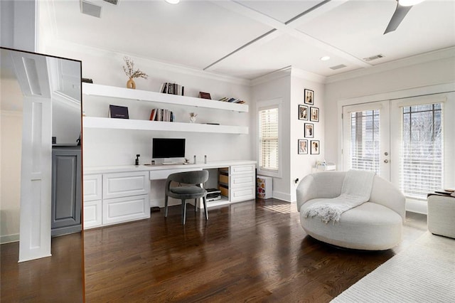 office featuring built in desk, ornamental molding, ceiling fan, dark wood-type flooring, and french doors