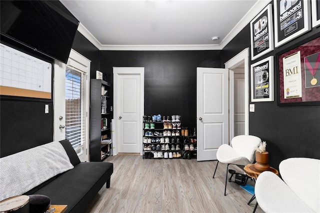 sitting room featuring crown molding and light wood-type flooring