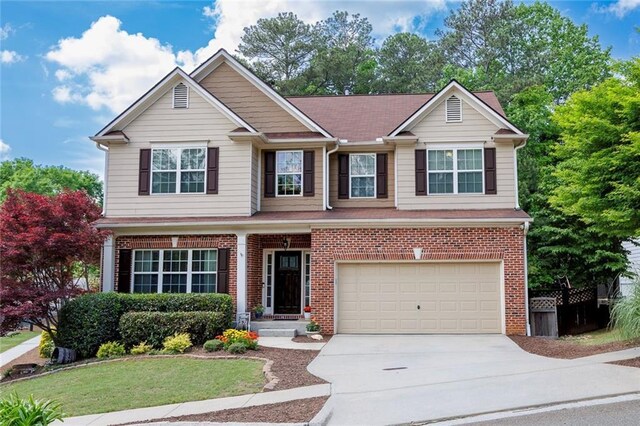 view of front facade featuring driveway, a garage, brick siding, and a front yard