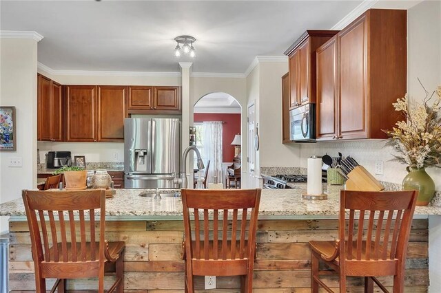 dining area with arched walkways, wood finished floors, a ceiling fan, crown molding, and a chandelier