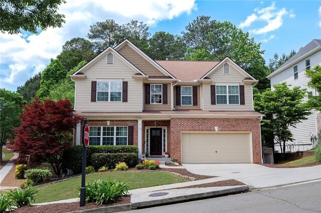 view of front of home featuring concrete driveway, brick siding, a garage, and fence