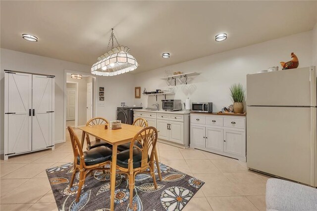 dining room with light tile patterned floors and washer and dryer