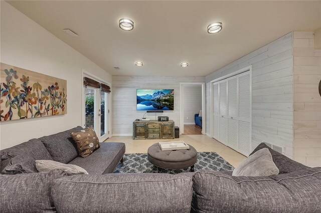tiled living area with wood walls and recessed lighting