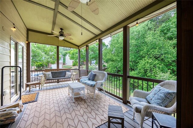sunroom with a ceiling fan and an outdoor living space