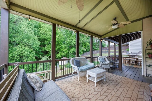 sunroom with ceiling fan and vaulted ceiling