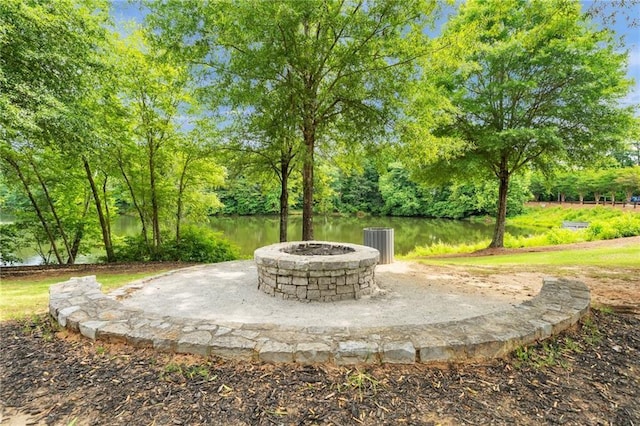 view of patio with an outdoor fire pit, a water view, and central air condition unit