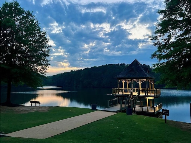dock featuring a water view, a gazebo, and a lawn