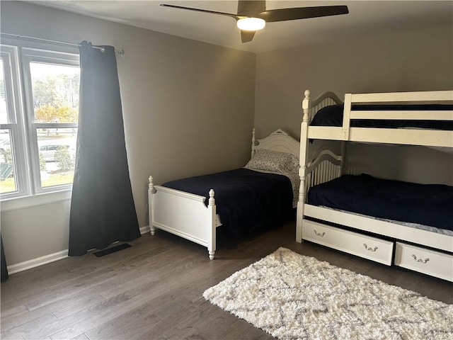 bedroom with multiple windows, dark wood finished floors, visible vents, and baseboards